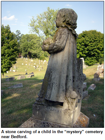 A stone carving of a child in the “mystery” cemetery near Bedford.  